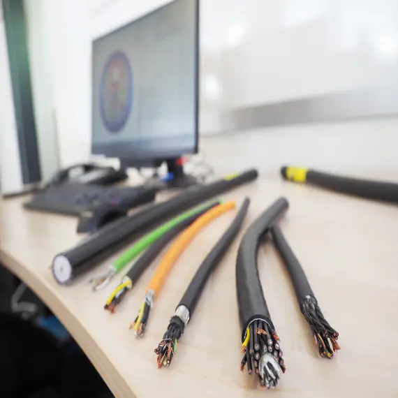 Seven (7) industrial cables laid out on a computer desk next to a keyboard and monitor